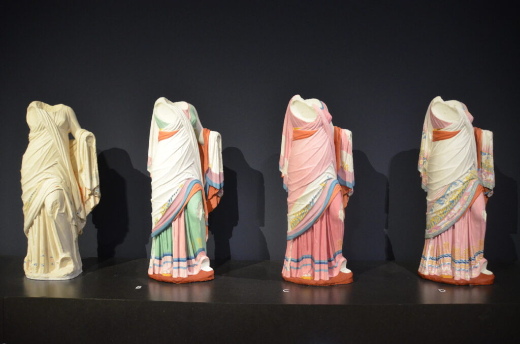 Four painted plaster figures of a woman.